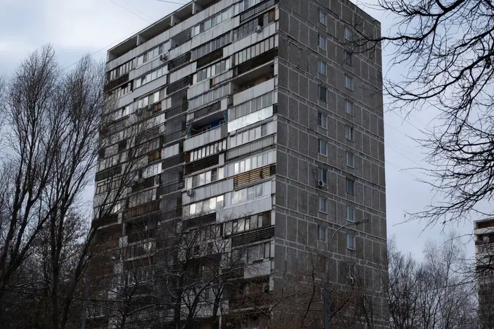Панельна шістнадцятиповерхівка серед голих дерев